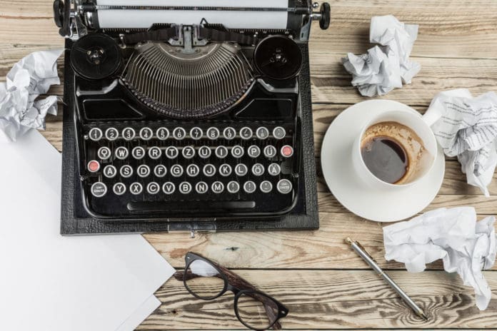 Typewriter next to coffee mug on the table